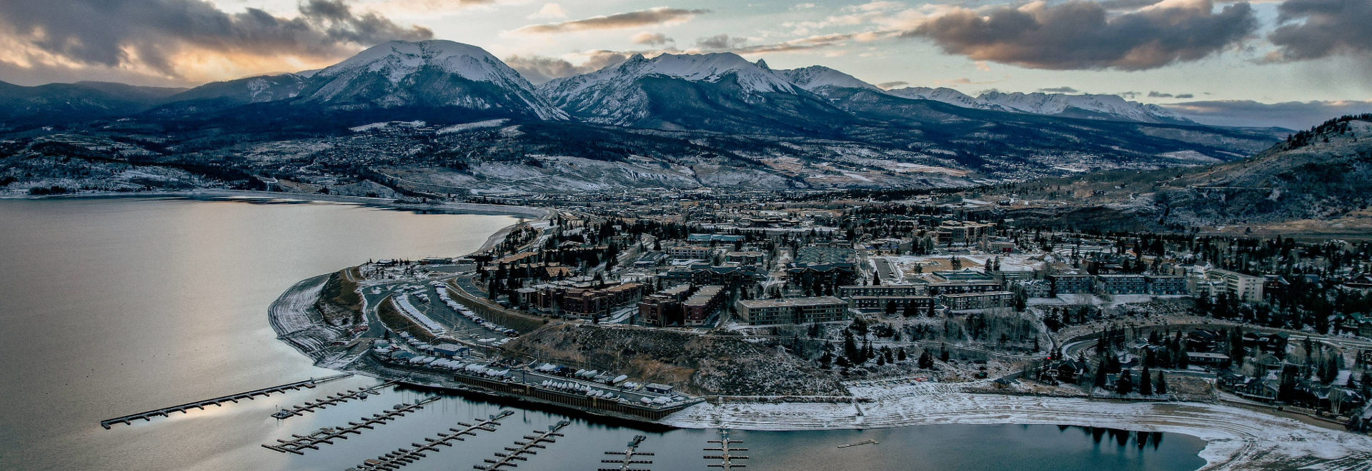 An aerial image depicting a cityscape adjacent to impressive mountains, illustrating the harmonious blend of urban and natural environments